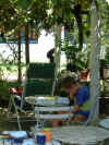Luuk maakt schoolwerk onder de druiventrossen...